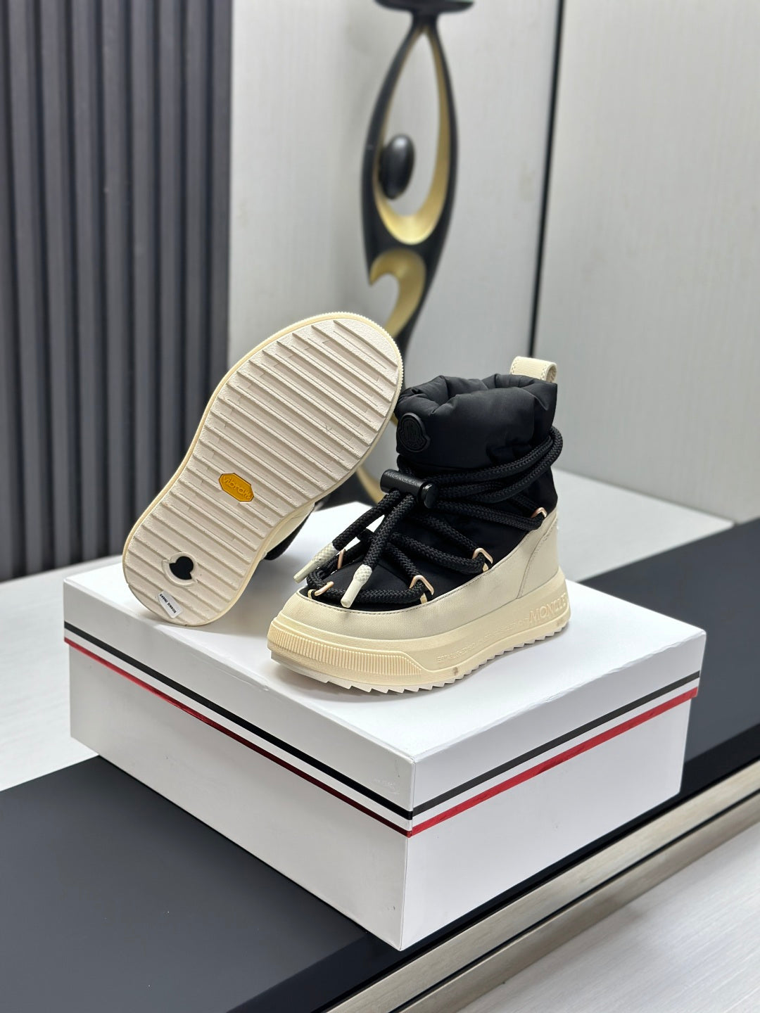 Moncler sneakers shown from outsole, black upper with cream treaded sole