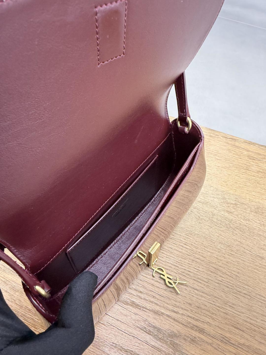 YSL burgundy mini bag open with gold YSL logo hardware and visible interior