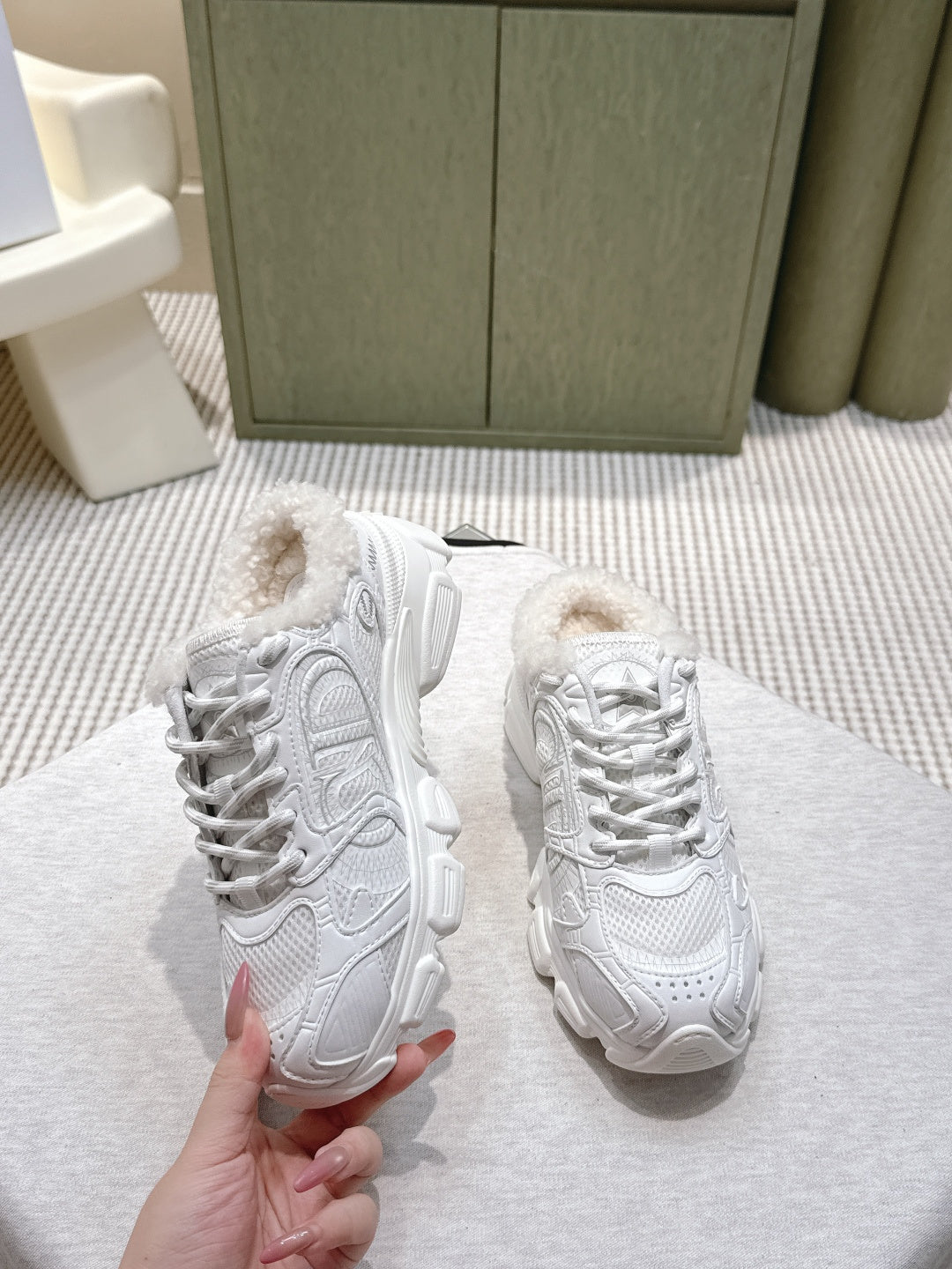 White fur-lined sneakers shown from the side with chunky sole and lace-up design