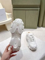 White sneakers with patterned tread outsole visible on the back and lace-up top