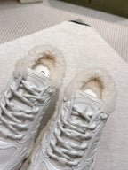 Close-up of white lace-up sneakers with fuzzy lining and textured overlay detailing