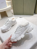 Pair of white sneakers with fuzzy lining and embossed pattern on the side