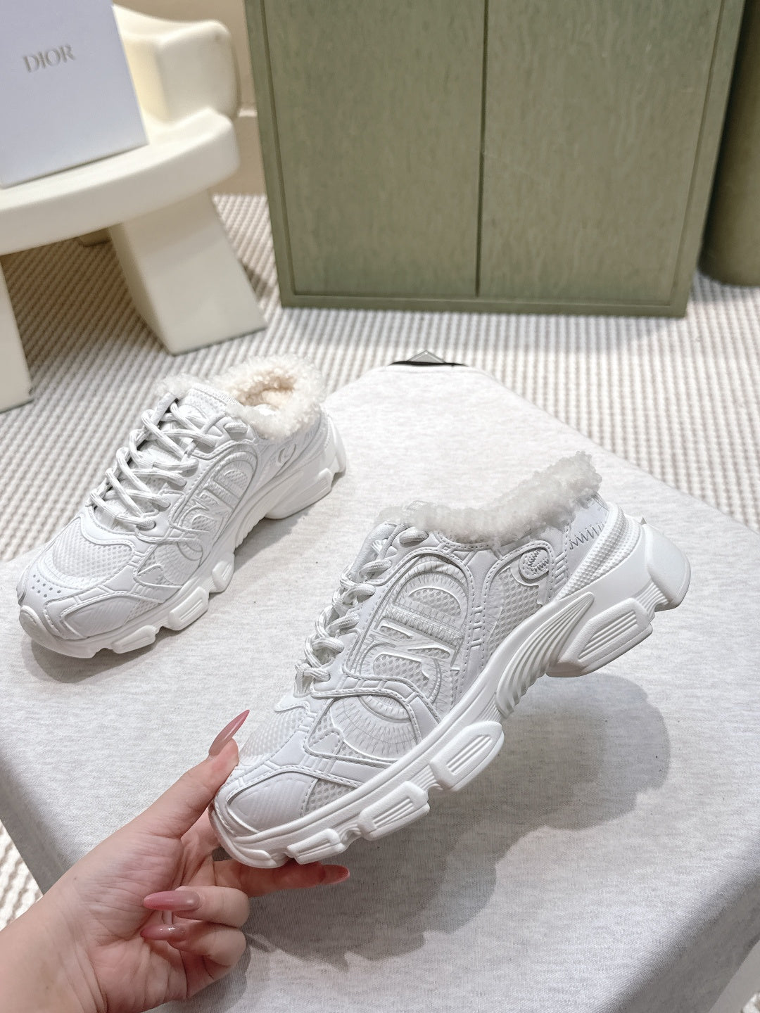Pair of white sneakers with fuzzy lining and embossed pattern on the side