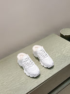 White pair of sneakers resting on a display surface with fuzzy lining at the collar