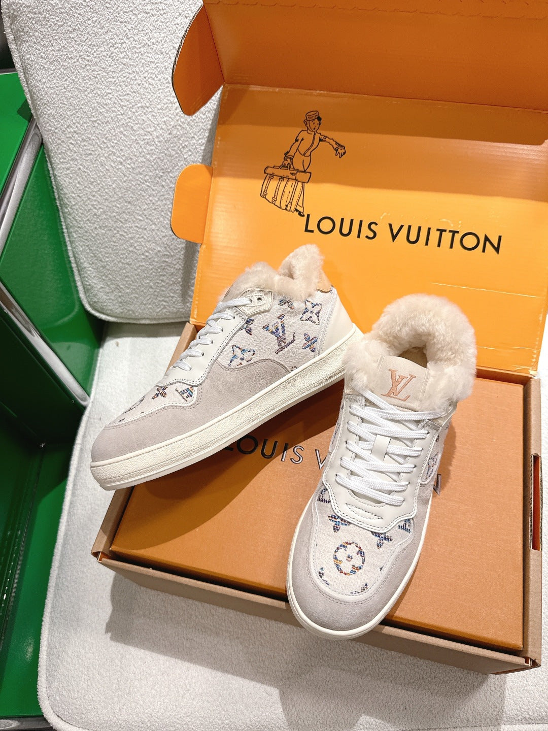 White Louis Vuitton high-top sneakers with monogram print and white lace-up design