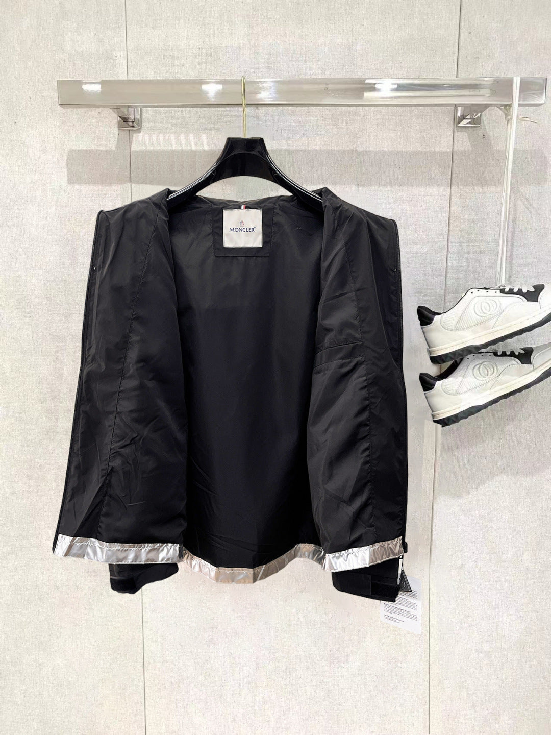 Moncler long jacket with black outer shell and visible interior lining