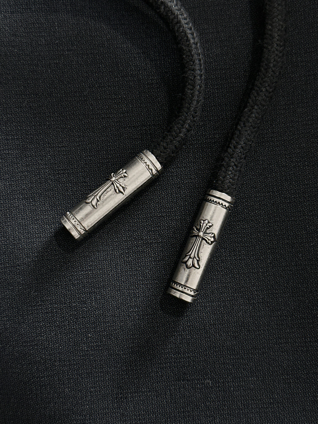 Metal drawstring tips on dark pants
