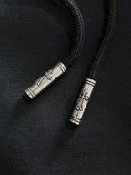 Metal drawstring tips on dark pants