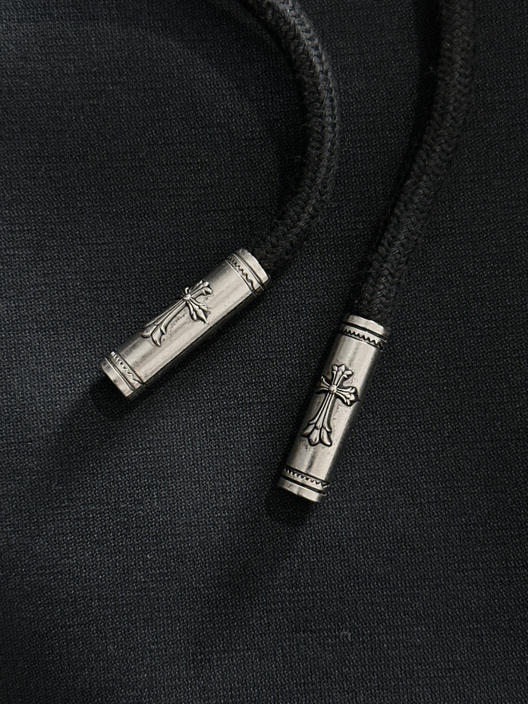 Metal drawstring tips on dark pants