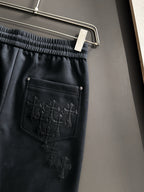 Dark pants with elastic waist and front side pocket, stitched cross panel