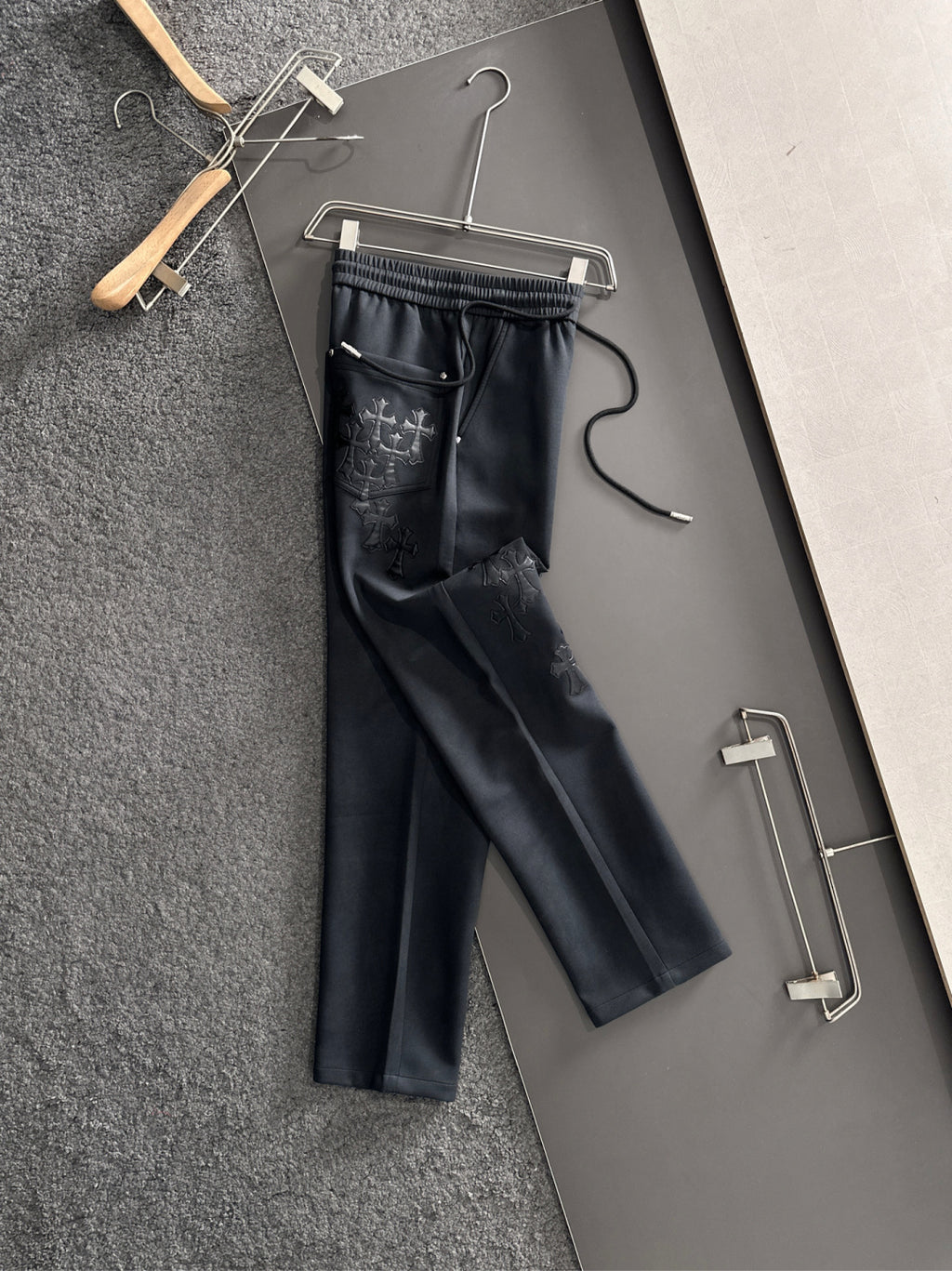 Dark straight-leg pants with elastic waistband, drawstring, side pocket with cross stitch