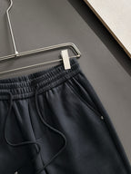 Dark pants waistband close-up with elastic gathers and drawstring cord