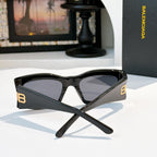 Black sunglasses with dark tinted lenses and gold BB accents on temples