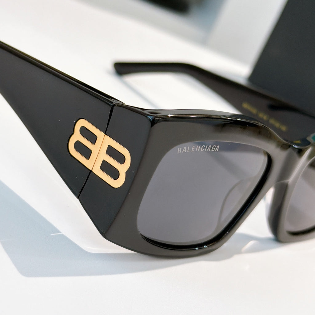 Black sunglasses with gold BB emblem on temple and dark tinted lenses