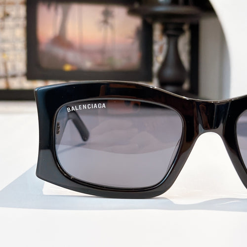 Black oversized sunglasses with dark lenses and BALENCIAGA branding near temple