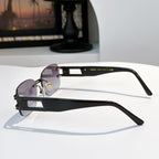 Sunglasses with purple lenses and black frame, gold-tone hardware on temples