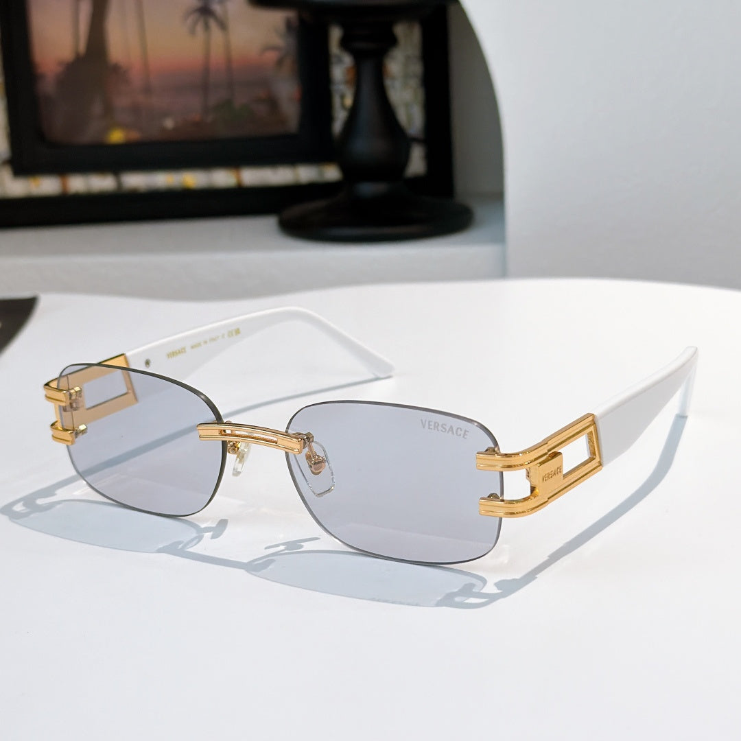 Sunglasses with smoke-gray lenses and gold frame, curved cat-eye silhouette