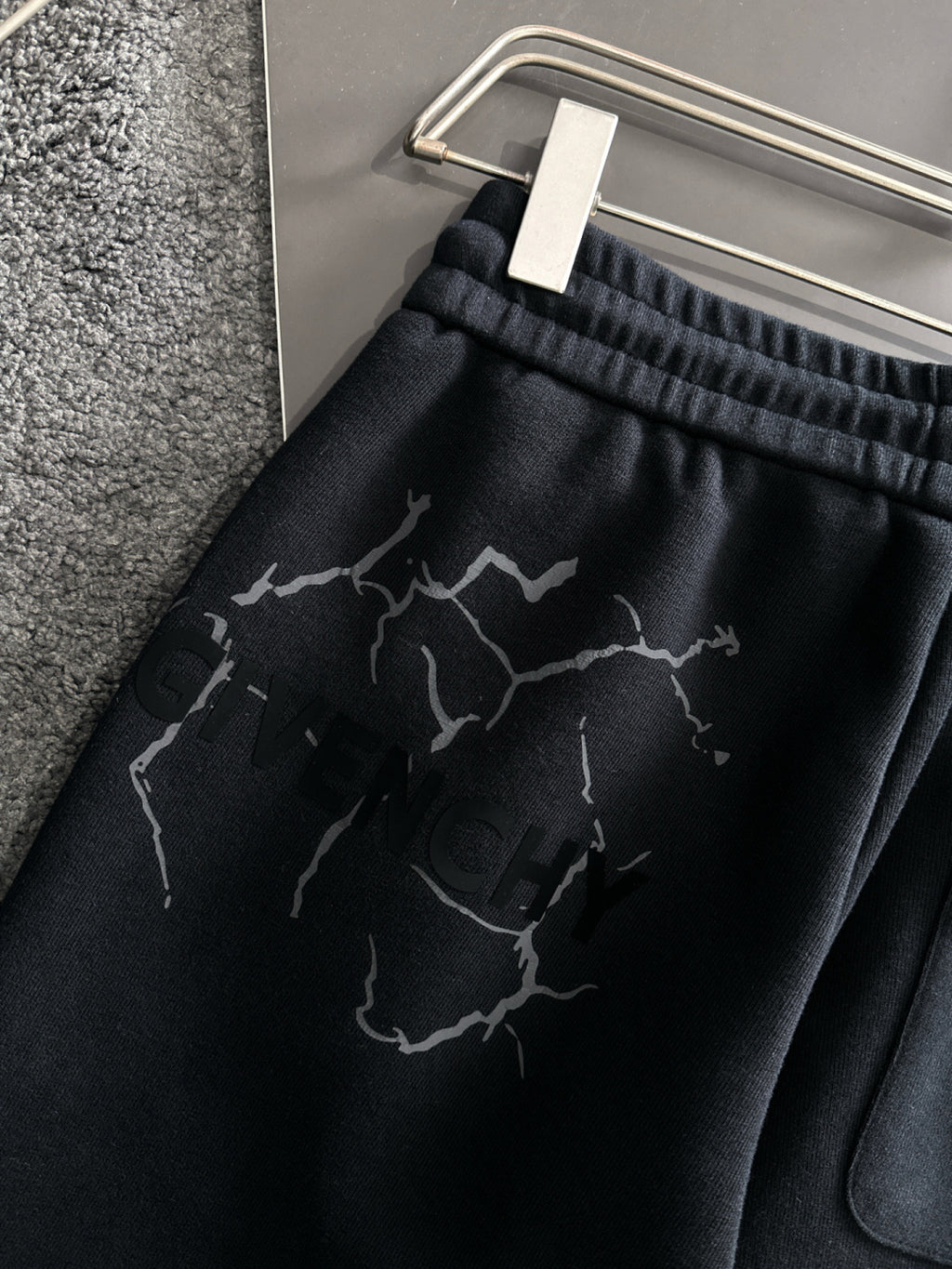Black sweatpants waistband and leg panel with abstract crack-style graphic print