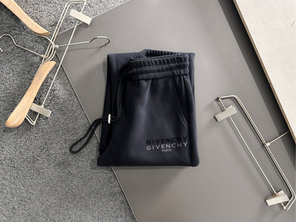 Black Givenchy Paris drawstring pants with elastic waistband, displayed folded on hangers