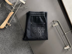 Dark pants with elastic waist and drawstring, side pocket with stitched cross design