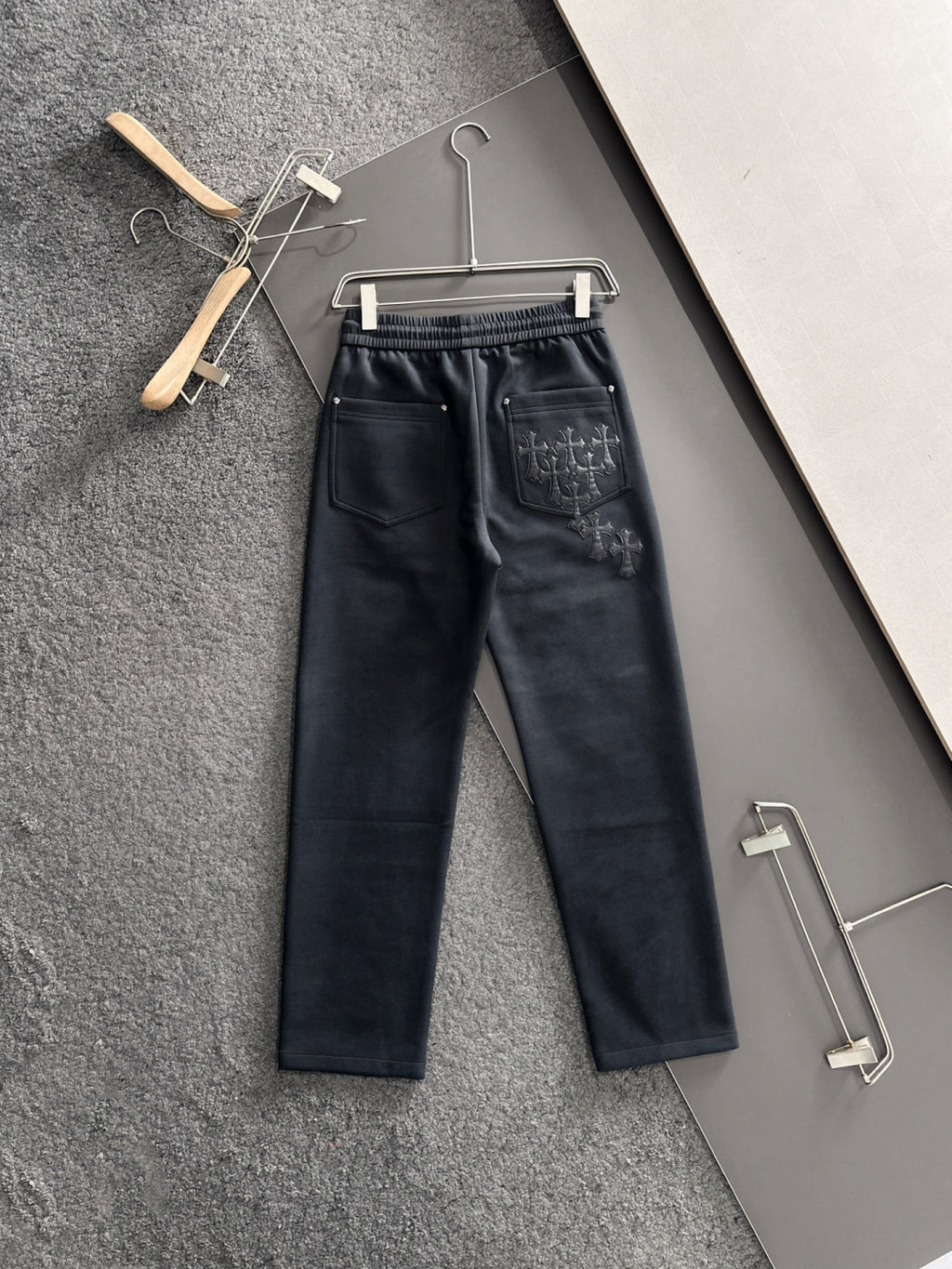 Dark pants with elastic waistband and drawstring, side pockets and cross embroidery