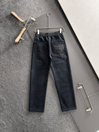Dark pants with elastic waistband and drawstring, side pockets and cross embroidery