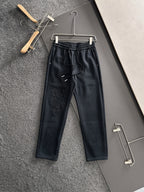 Dark pants with elastic waist, drawstring, side pockets, embroidered cross pattern