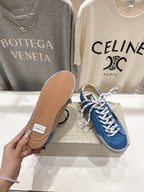 Blue sneaker outsole view with textured gum tread and white laces
