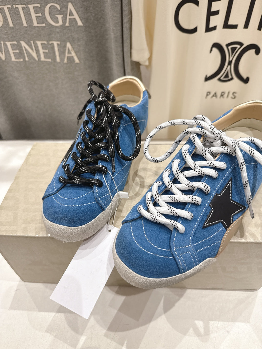 Pair of blue low-top sneakers with black and white laces, gum soles