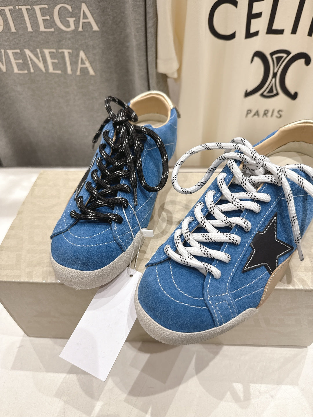 Pair of blue low-top sneakers with black and white laces, gum soles