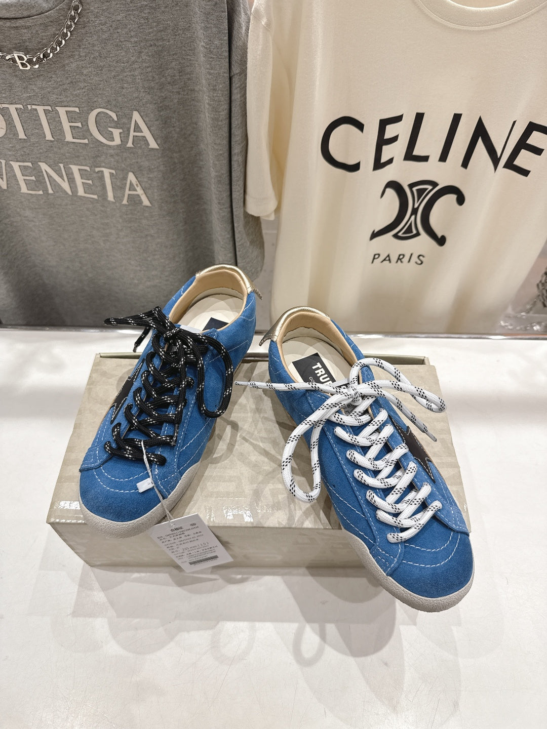 Blue high-top sneakers with white laces and black star patch detail, gum sole