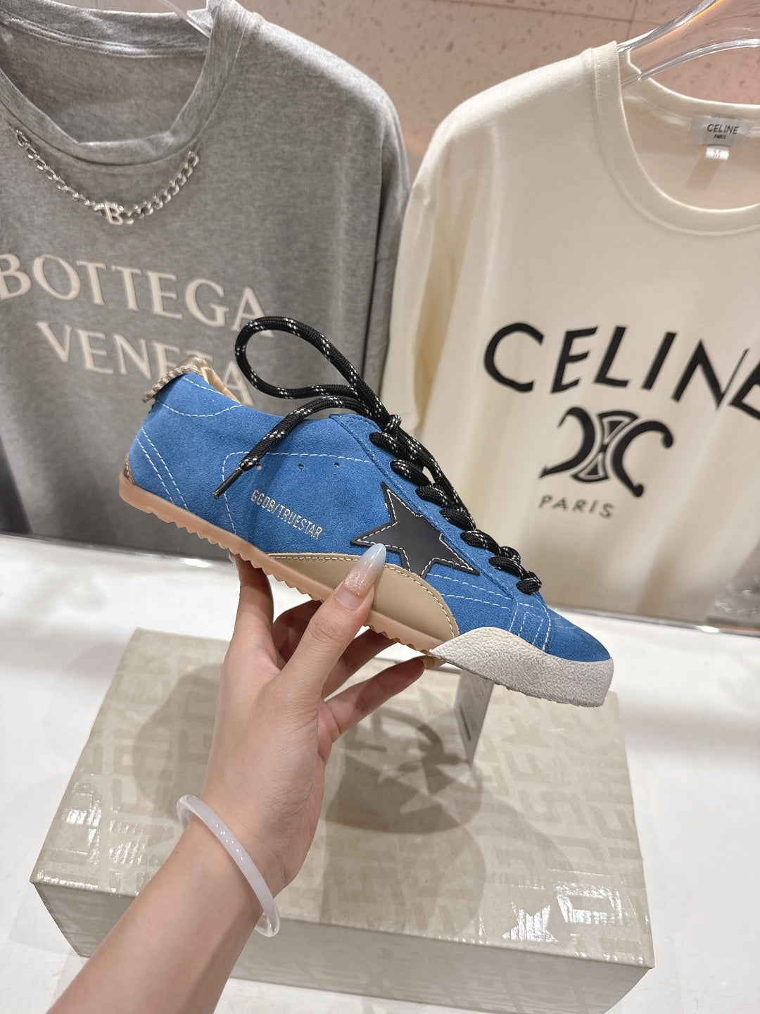 Blue low-top sneakers with black lace bow detail and white lace accents, gum sole