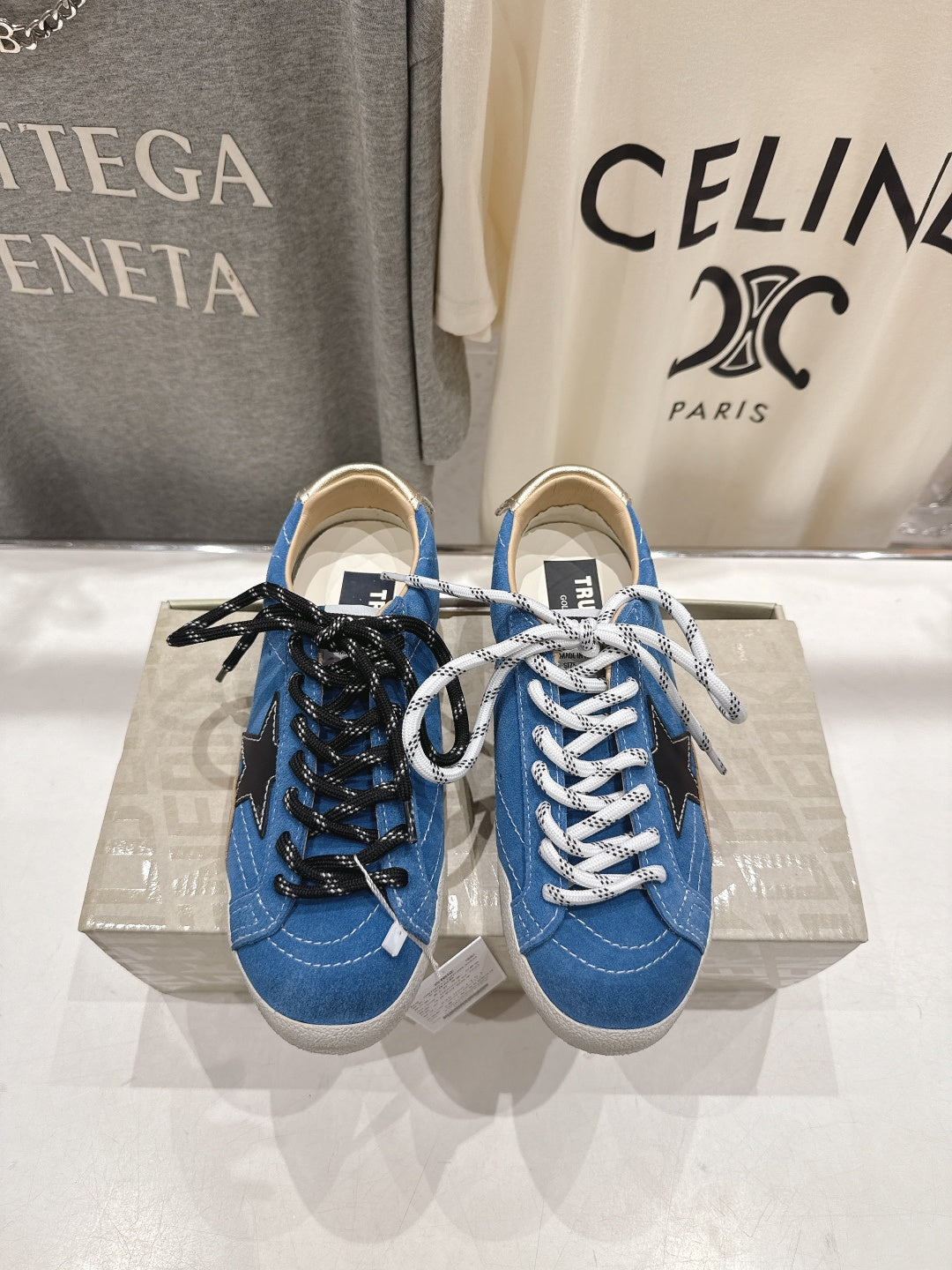 Blue high-top sneakers with white laces and black star patch, gum sole