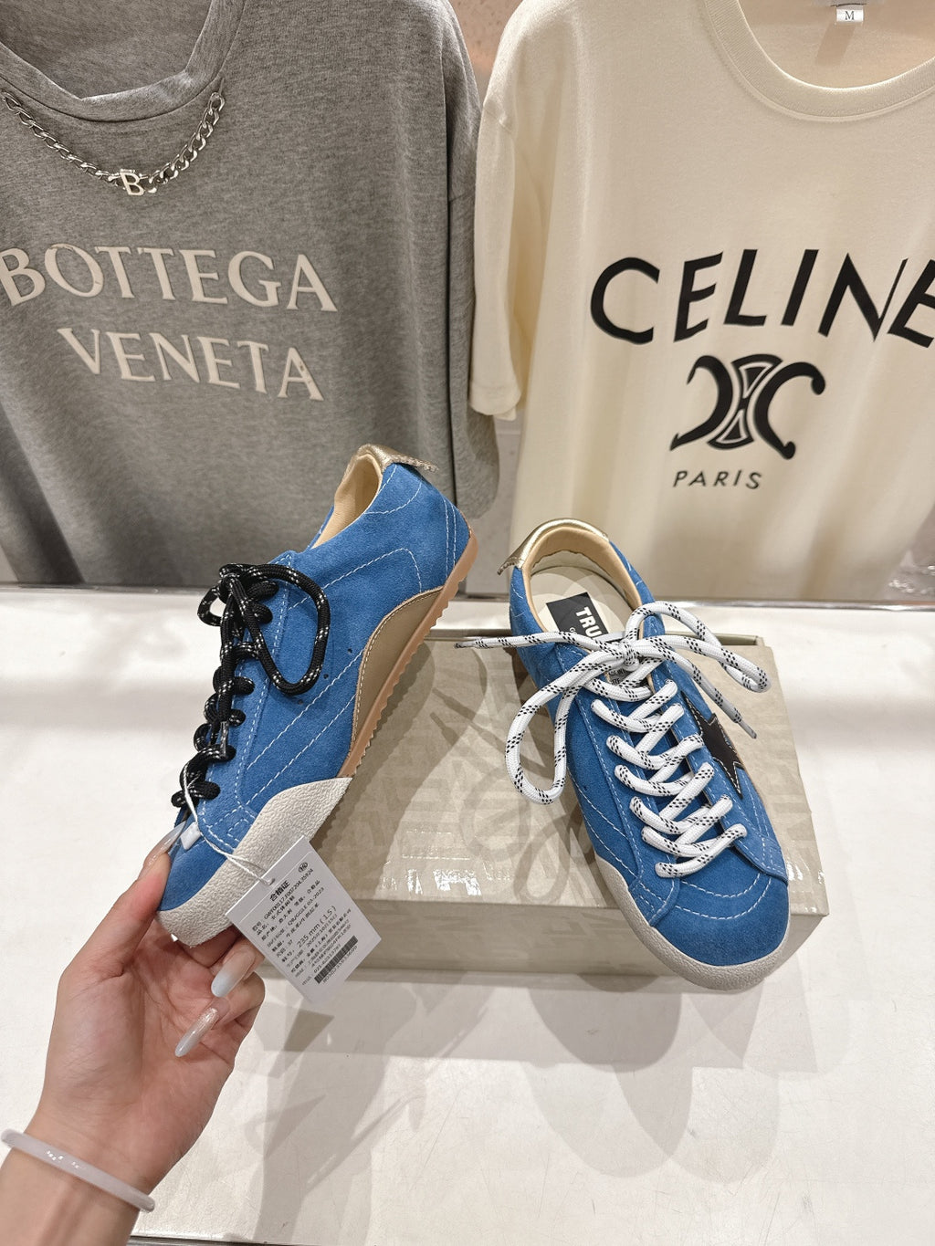 Blue high-top sneakers with white laces and black decorative lace detail, gum sole