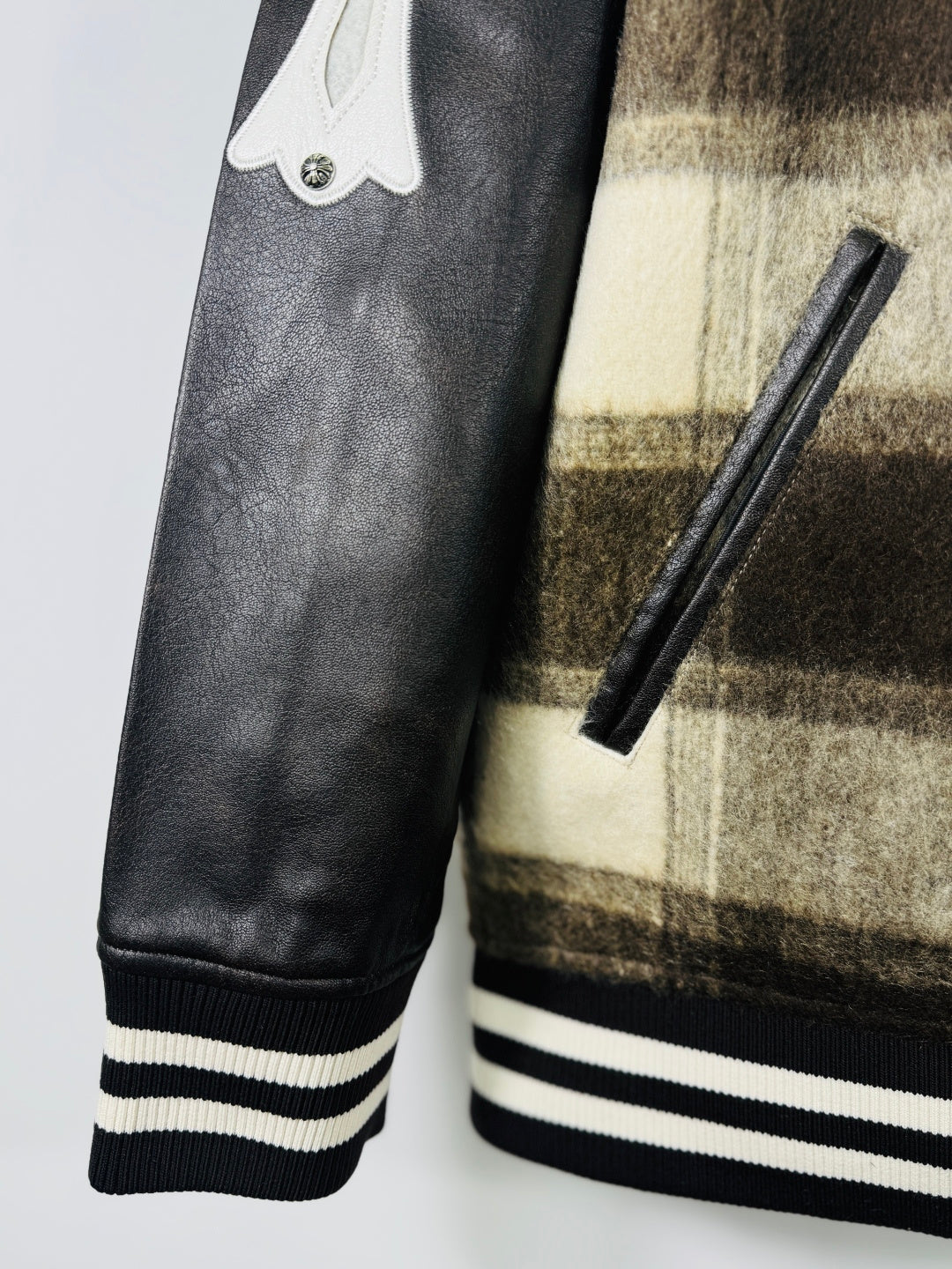 Leather-look sleeve with ribbed striped cuff on plaid varsity jacket