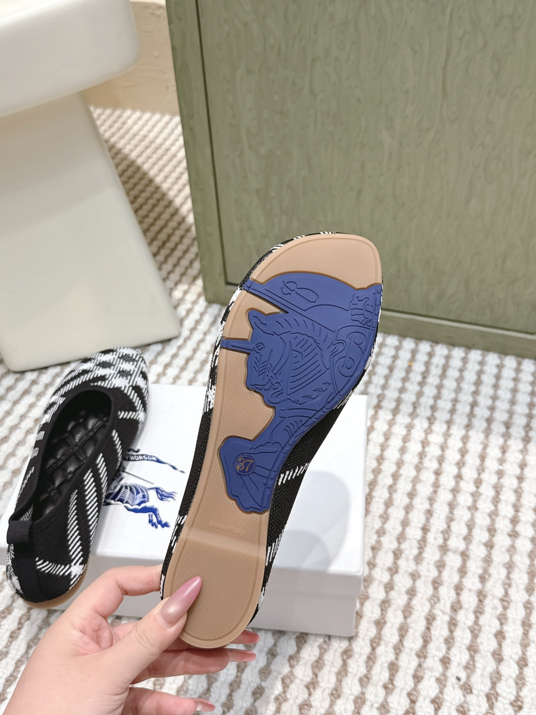 Burberry shoe outsole, tan base with blue tread shown under slip-on shoes