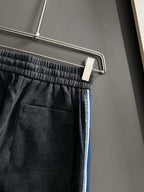 Dior pants front pocket area with elastic waistband and blue side stripe trim