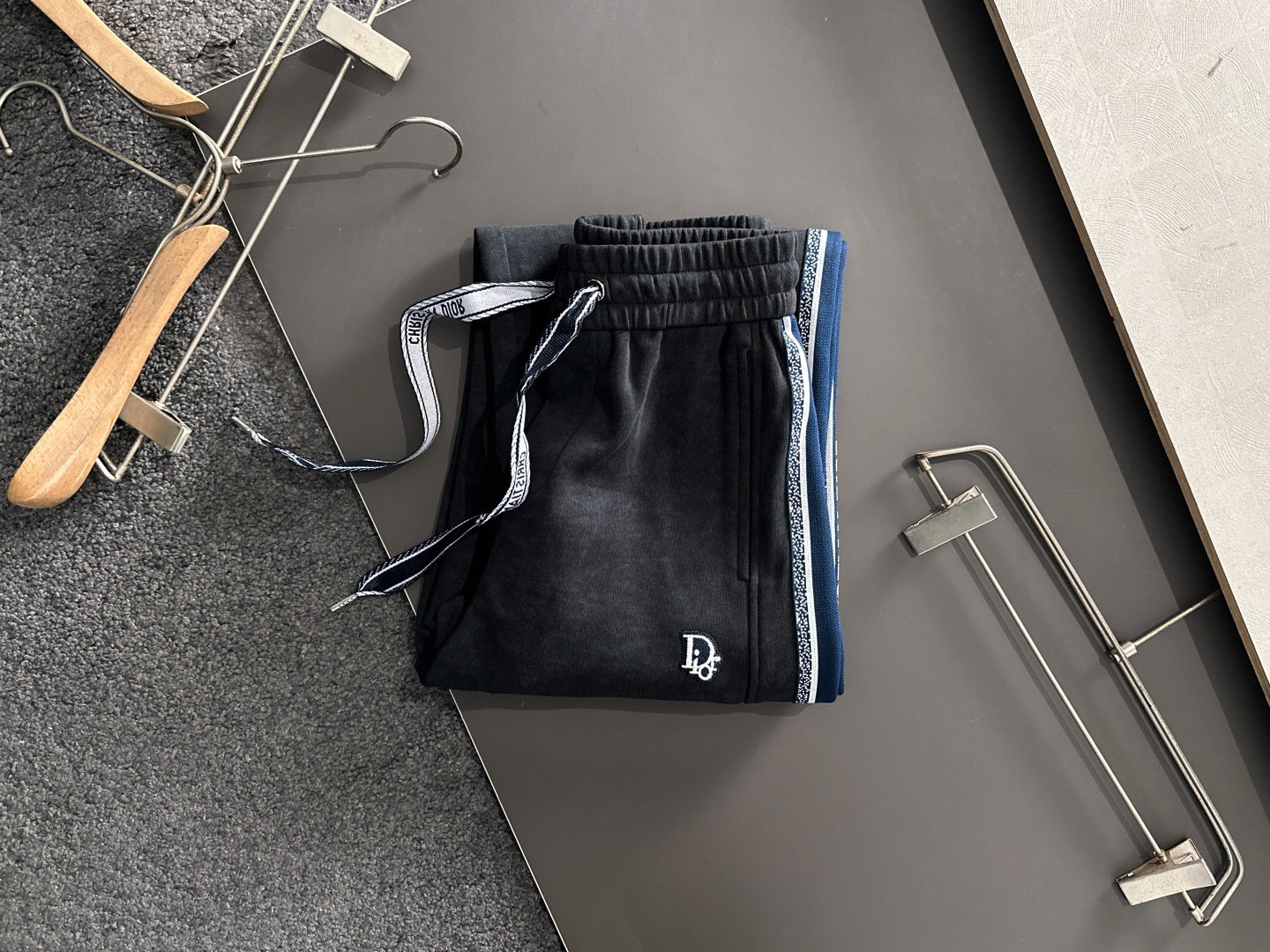 Dior pants with elastic waistband and drawstring; dark fabric with blue trim stripe