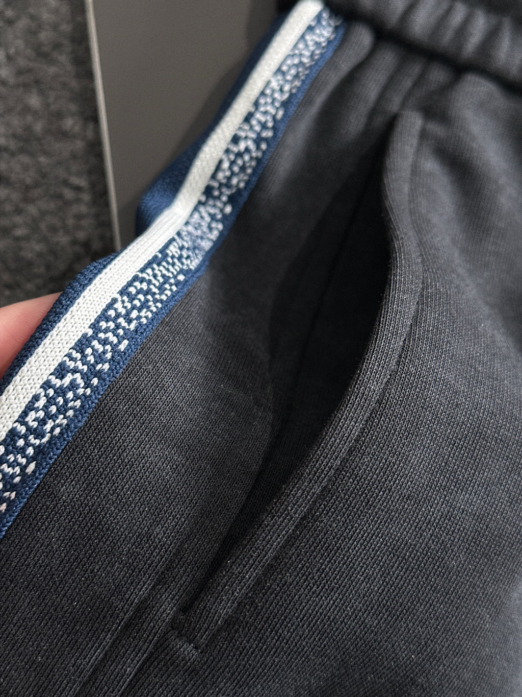 Dior pants waistband and side stripe close-up with blue trim and drawstring ties