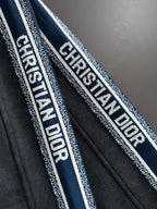 Dior pants side stripe detail with repeating logo text on blue and white trim