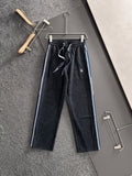 Dior pants in dark fabric with elastic waist, drawstring, and blue side stripes