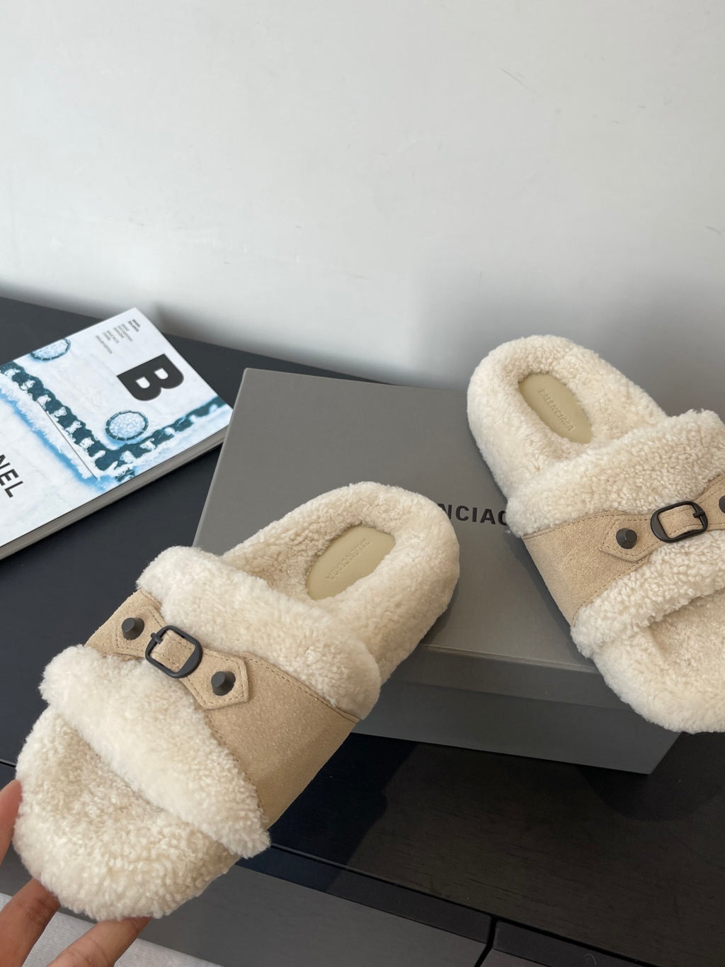 Beige fuzzy slide sandals with top strap and buckle, side view