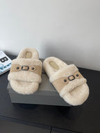 Beige shearling slide sandals with buckled strap, angled front view