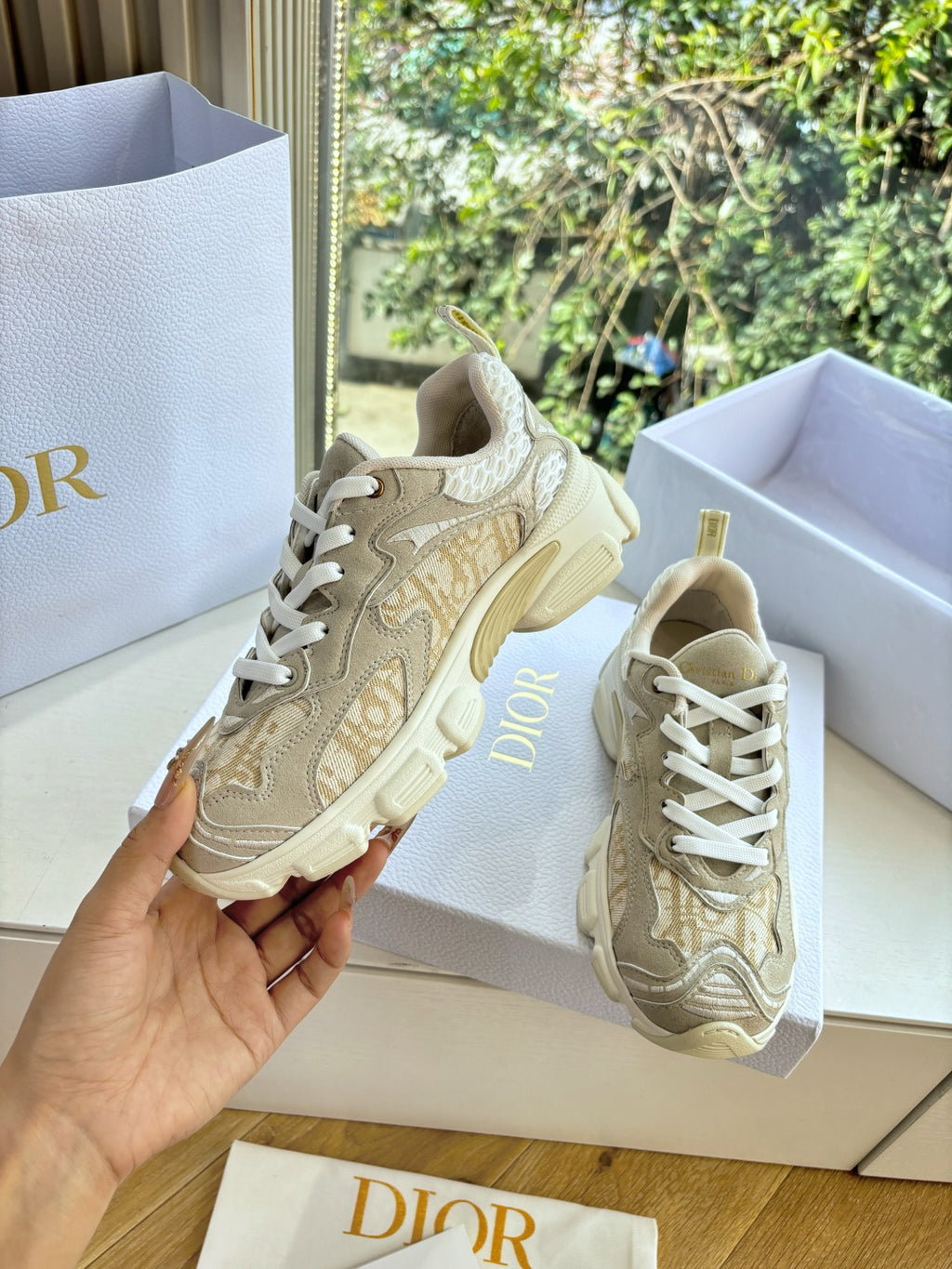 Beige lace-up sneakers held up, with star and patterned detailing