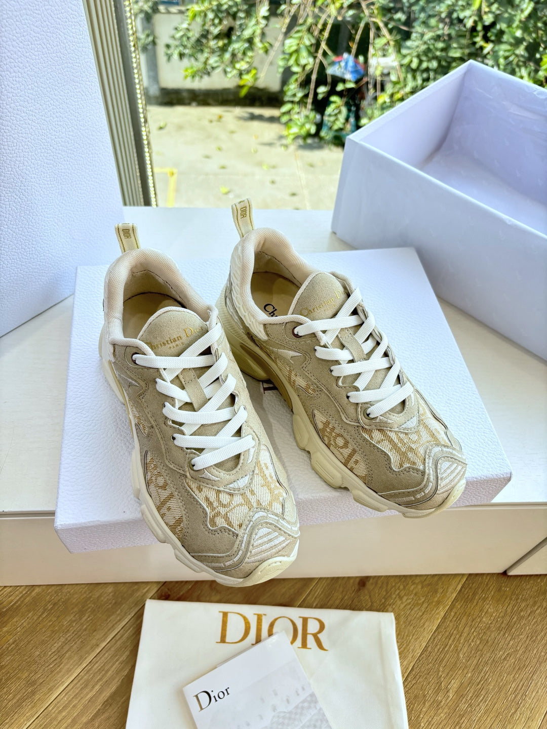 Beige lace-up sneakers with white laces and textured patterned uppers