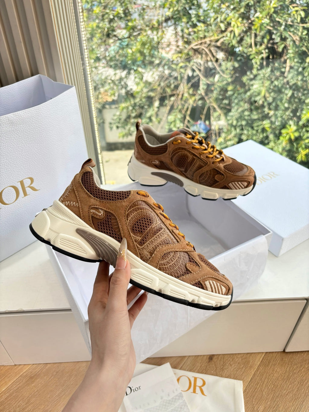 Brown and tan lace-up sneakers with white sole, mesh upper and stitched overlay