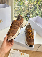 Brown lace-up sneakers in hand, chunky white sole with tan laces