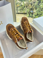 Brown lace-up sneakers with perforated panels and gold laces, side view