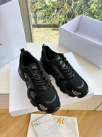 Black lace-up sneakers side view in a white shoe box