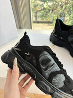 Black lace-up sneakers close-up with breathable mesh and thick sole